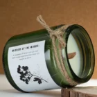 Detail sójové svíčky s dřevěným knotem v zelené skleněné dóze položené na boku