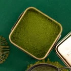 Detail jemně mletého japonského bio matcha prášku v prémiové plechovce při tradiční přípravě ceremoniálního matcha čaje