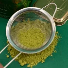 Prosévání jemně mletého bio matcha prášku z Japonska při tradiční přípravě ceremoniálního matcha čaje